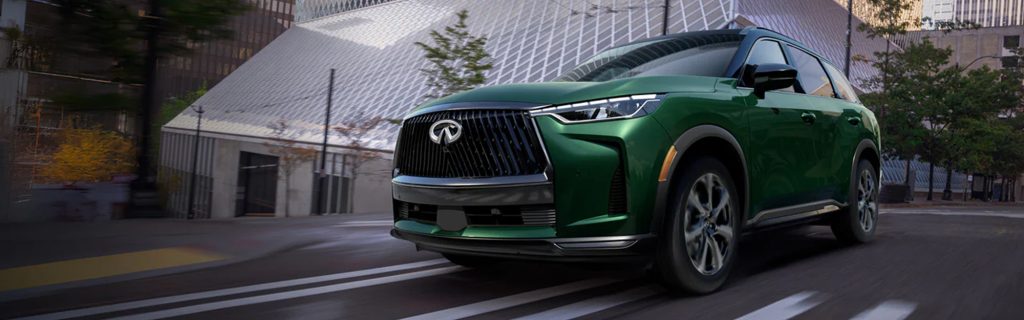 2027 INFINITI QX60 driving through a modern city street